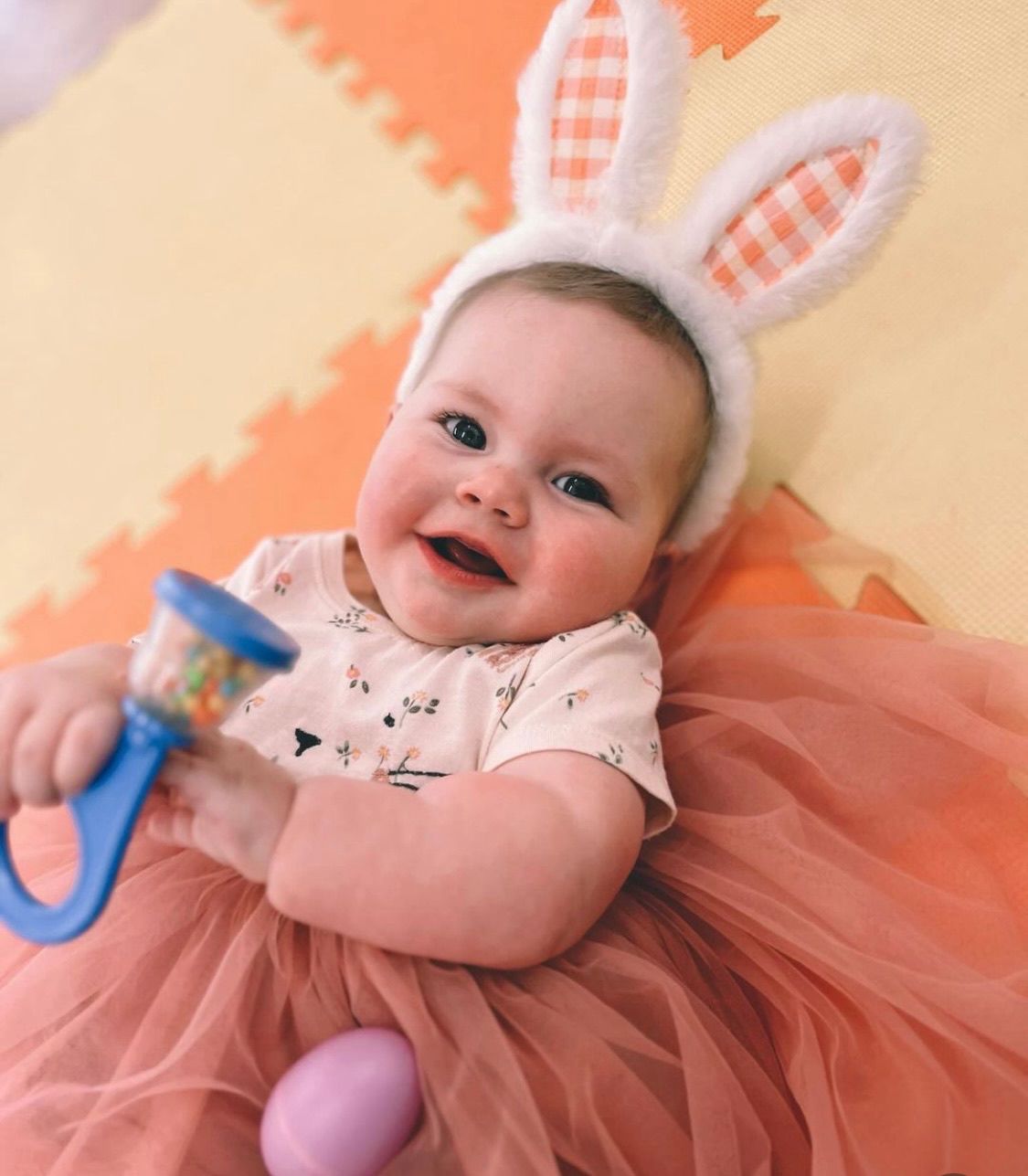 Baby dressed as easter bunny with rattle